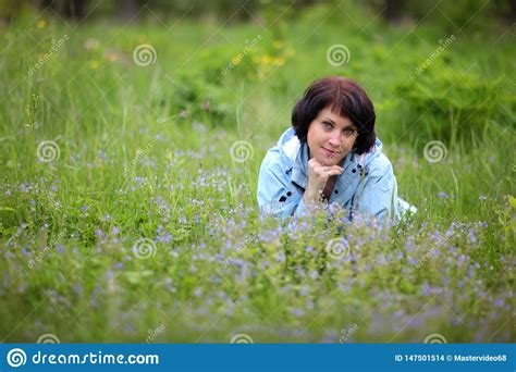 Beautiful Mature Woman Posing For The Camera In The Spring Garden The Girl Enjoys The Flowering