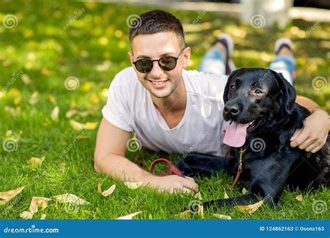 Guy With A Dog Labrador On The Street Playing Stock Image Image Of