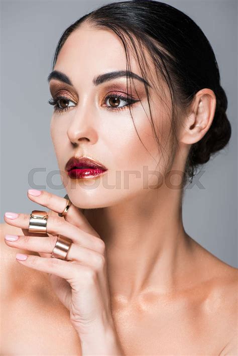 Portrait Of Naked Girl Posing With Golden Rings On Hand Isolated On