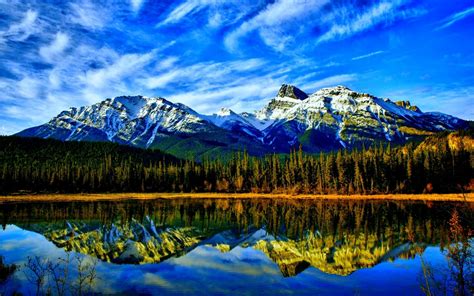 Nature Landscape Mountain Peaks With Snow Green Forest With Pine Trees Peaceful Lake Water Blue