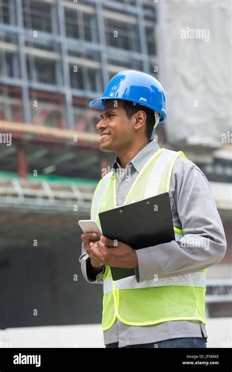 Portrait Of A Male Indian Builder Or Industrial Engineer At Work Using