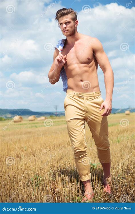 Topless Man Outdoor Walking On The Field With Straw In Mouth Stock