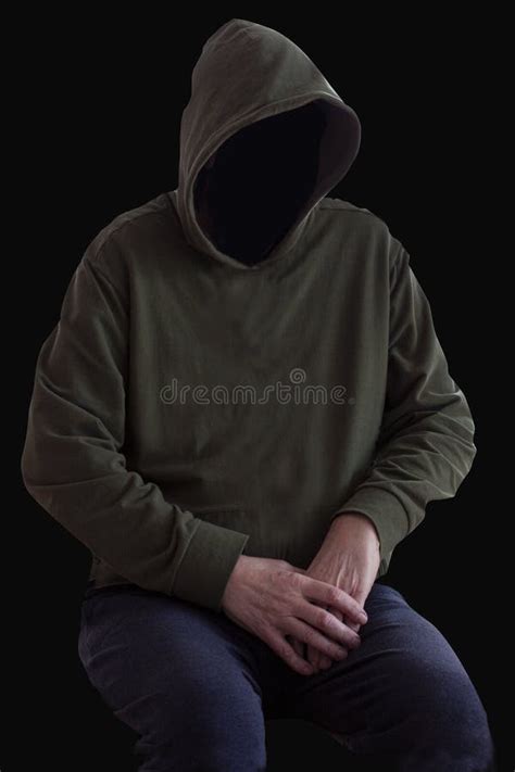 Faceless Person In Hoodie Sitting In The Darkness With Hands Crossed Mystery Man With Hood