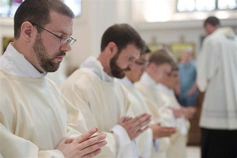 The Five Newly Ordained Priests Pray Before The Congregation Photo By