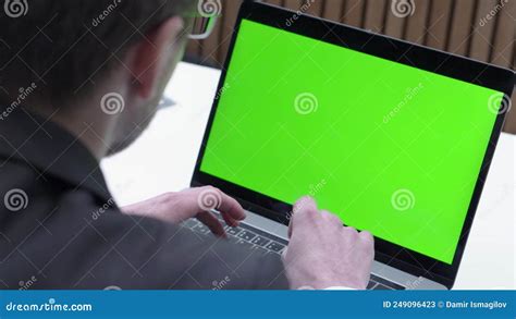 Over The Shoulder Shot Of A Businessman Typing On Laptop And Looking At