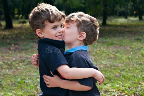 Identical Twin Brothers Embraced Each Other With A Kiss Stock Photo