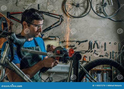 Competent Bicycle Mechanic In A Workshop Repairs A Bike Stock Photo