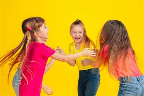 Happy Children Playing And Having Fun Together On Yellow Studio