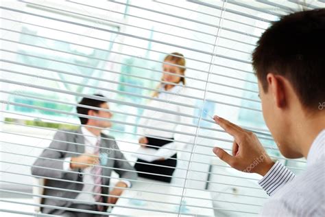 Businessman Looking Through Blinds At His Colleagues — Stock Photo