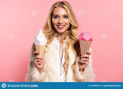 Blonde Woman In White Faux Fur Jacket Holding Paper Decorative Ice Cream Isolated On Pink Stock