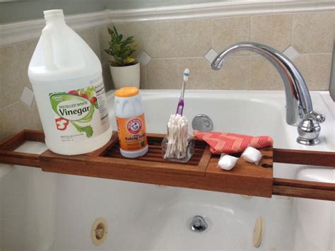 A Bathroom Sink With Soap Toothbrushes And Other Cleaning Products On It Next To A Bathtub