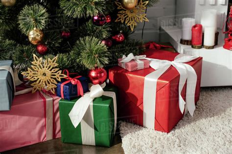 T Boxes Under Christmas Tree With Baubles In Room Stock Photo