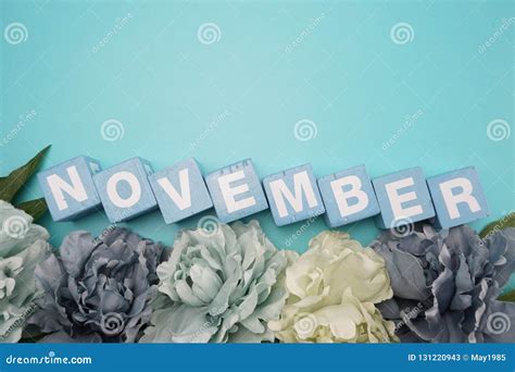 November Alphabet Letters With Flower Bouquet On Blue Background Stock