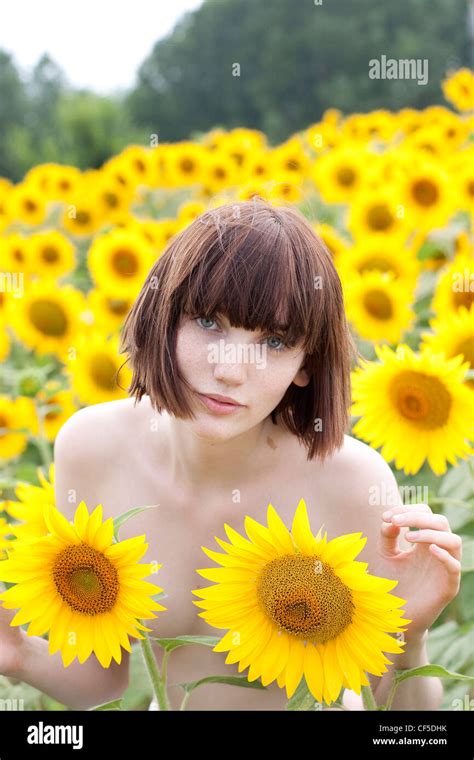 Female With Short Fringed Brunette Hair Standing Nude In The Sunflower Field Unsmiling