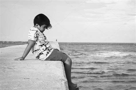 Cute Little Boy Sitting Alone On Walkway At Sea — Stock Photo