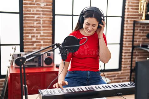 Young Woman Musician Playing Piano Keyboard At Music Studio Stock Photo