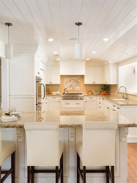 A large peninsula overlooks the dining and living room for an open concept. White Cabinets Tan Granite | Houzz