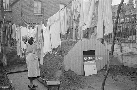 A Woman Hanging Out Her Washing Next To The New Anderson Air Raid