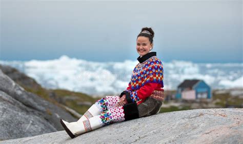 Young Inuit Woman In Traditional Clothing Posing For Photos In A Small Greenlandish Village