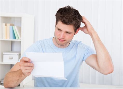 Confused Man Looking At Paper Stock Photo Image Of Contemplated