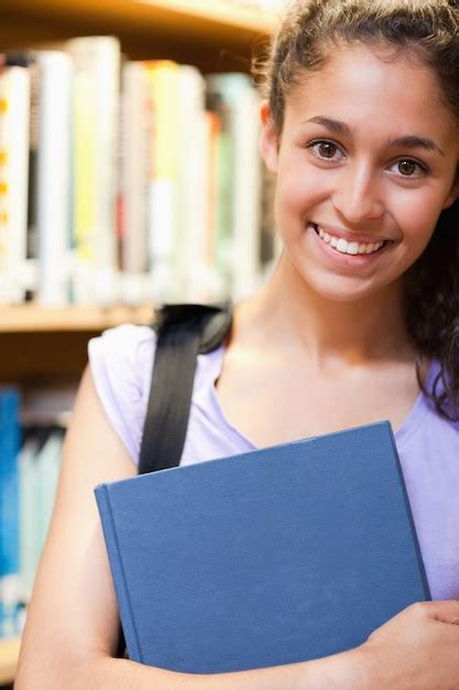 Premium Photo Portrait Of A Happy Female Student Holding A Book