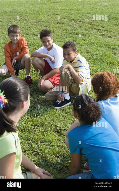 Group Of Children Kneeling On The Grass Stock Photo Alamy