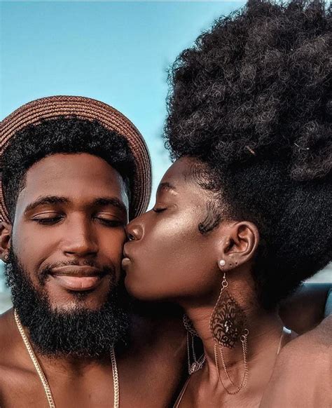 A Man And Woman Kissing Each Other While Wearing Gold Necklaces On