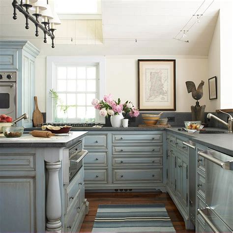 A stylish blue kitchen with stainless steel appliances, touches of natural wood and brass is a super chic and cool space. Blue Kitchen Cabinets - Cottage - kitchen - BHG