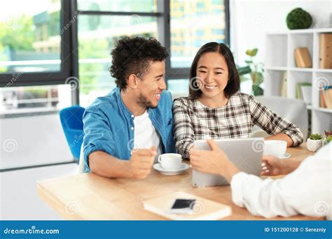 Happy Interracial Couple With Real Estate Agent In Office Stock Photo Image Of Male Loan