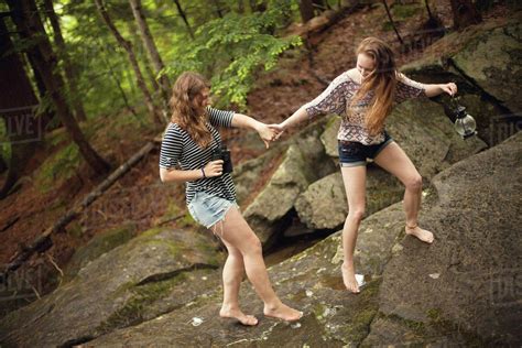 Girls Walking Barefoot On Boulder In Forest Stock Photo Dissolve