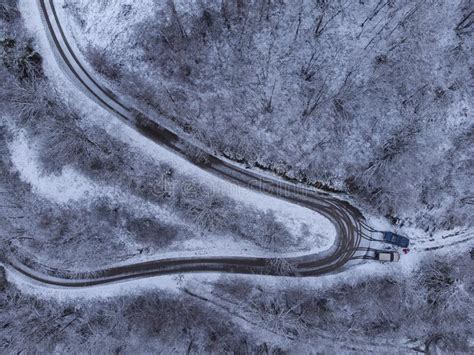Drone Overhead Shot Of Curved Road In Winter Mountain Landscape Stock