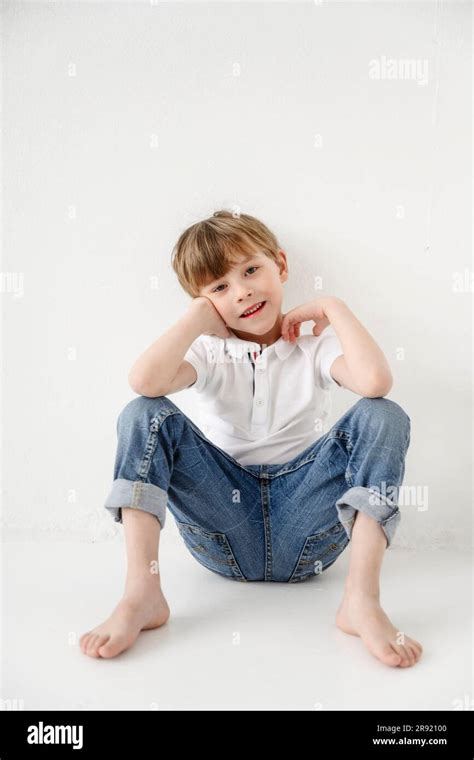 Boy Sitting In Front Of White Backdrop Stock Photo Alamy