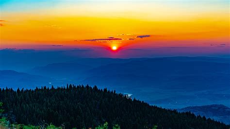 Download Wallpaper 1366x768 Sun Sunset Trees Mountains Landscape