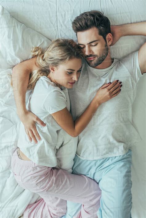 Top View Of Beautiful Young Couple Sleeping Together And Embracing In