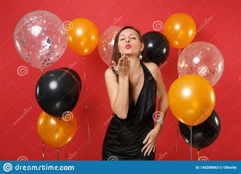 tender young girl   black dress celebrating blowing lips send air kiss  bright red