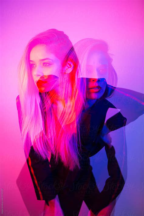 Double Exposure Photo Of A Beautiful Blonde Woman Lit With Blue And Pink Colours Looking In Two