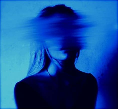 A Blurry Photo Of A Womans Head And Shoulders In Blue Light With Her
