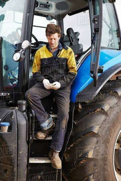 Farmer Using Cell Phone On Tractor Stock Photo Dissolve