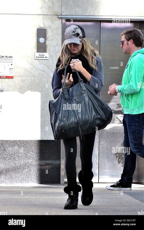 Ashley Tisdale Keeps Her Head Down Obscuring Her Face With Her Baseball