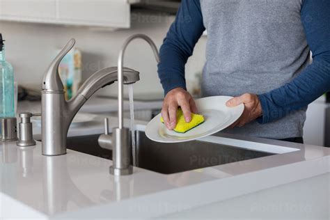 Man Washing Dishes In A Sink Stock Photo Pixeltote