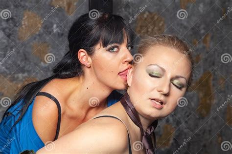 två sexiga lesbiska flickor som gör förälskelse på en svart säng i deras sovrum arkivfoto bild