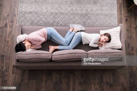 Mother And Daughter Napping On Sofa In Living Room Photos And Premium