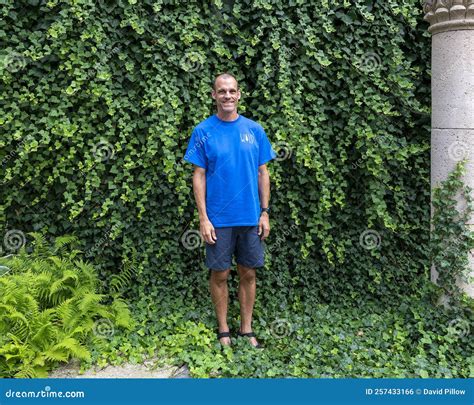 47 year old caucasian male standing in front of a dense wall of green ivy in bar harbor maine