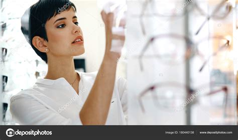 Beautiful woman with optician trying eyeglasses — Stock Photo © nd3000 #180440138