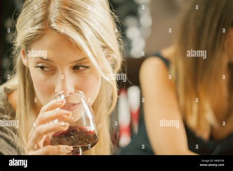 Blonde Woman Drinking Red Wine With Friend Stock Photo Alamy