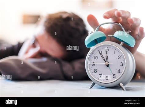 White Alarm Clock In The Morning Young Man Wakes Up Stock Photo Alamy