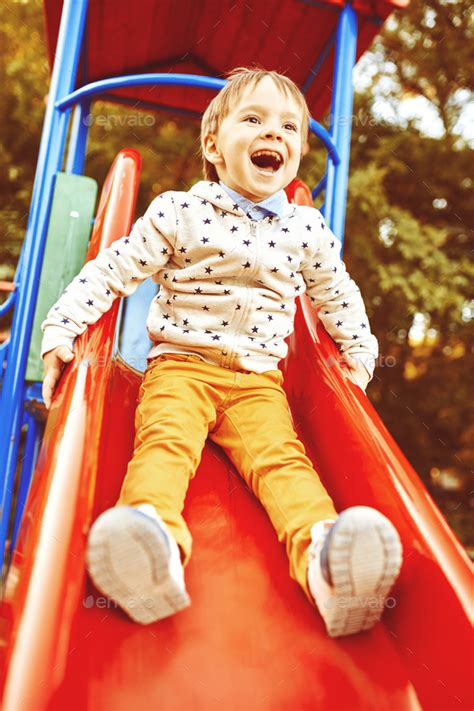 Little Boy Playing On Childrens Slides Stock Photo By Arthurhidden