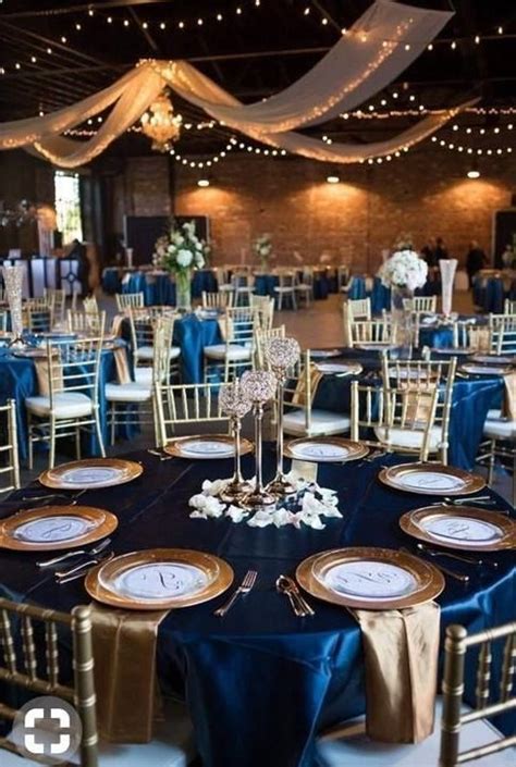 the tables are set up with blue and gold linens for an elegant wedding reception