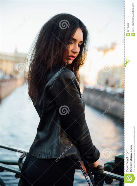 Portrait Of A Beautiful Brunette Posing On A Bridge On A River