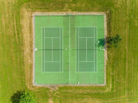 Aerial View Of Tennis Courts Surrounded By Grass And Trees Stock Photo